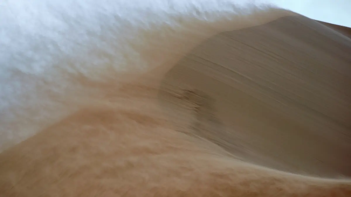 Dust storm sweeping across Qatar desert, symbolizing weather advisory for schools